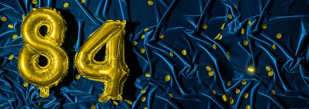 gold foil balloon number eighty four. Birthday or anniversary card with the inscription 84. blue velvet background. Anniversary celebration. Banner. copy space - Photo, Image