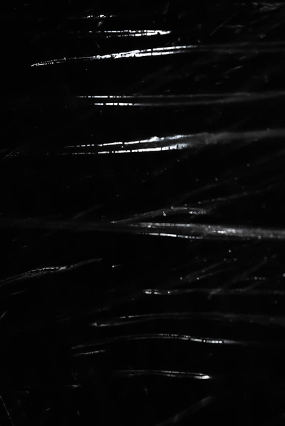 Абстрактный фон. Полиэтиленовый блеск Блестящие капли. Синтетический блеск на черном. Селективный фокус - Фото, изображение