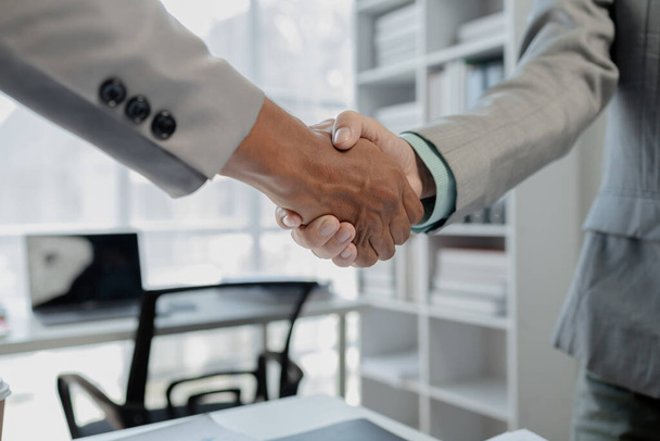 Meeting commitments in a meeting room at the office, Business people shaking hands in office, Shot of a businessman and businesswoman shaking hands, Handshake in contemporary office space, - Photo, Image