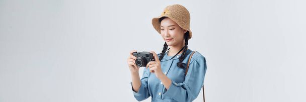Νεαρή κοπέλα που ταξιδεύει με κάμερα απομονωμένη σε λευκό - Φωτογραφία, εικόνα