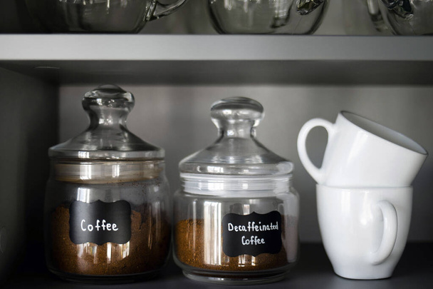 A polcon több fajta őrölt kávé van üvegedényekben. Reggeli kávé koncepció. A kávékészítés folyamata otthon. - Fotó, kép