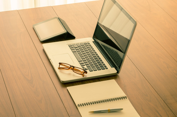 Портативный компьютер и офисные принадлежности на деревянном столе с винтом
 - Фото, изображение