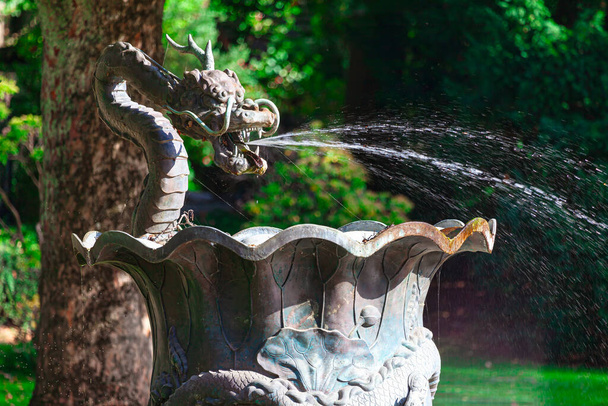 Chinesischer Drachenbrunnen mit plätscherndem Wasser im öffentlichen Park - Foto, Bild