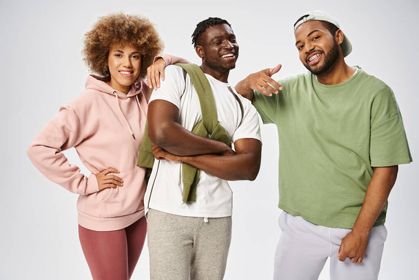 positivi amici afro-americani in posa insieme su sfondo grigio, celebrazione Juneteenth - Foto, immagini