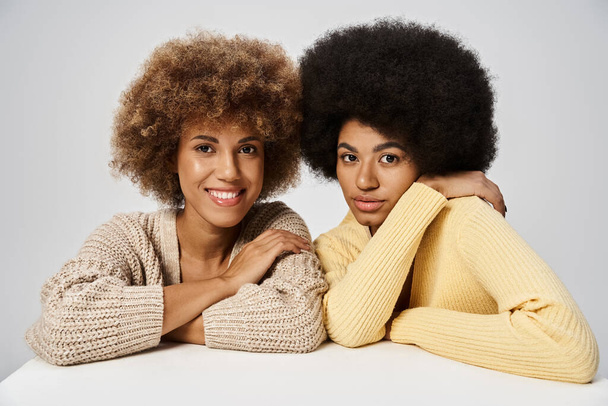 göndör és boldog afro-amerikai barátok áll elegáns öltözékben szürke háttér, Juneteenth - Fotó, kép