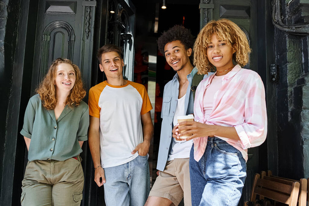 Mutlu ve modaya uygun çok ırklı öğrenciler şehir sokağındaki yurdun yakınındaki kameraya bakıyor, arkadaşlık - Fotoğraf, Görsel