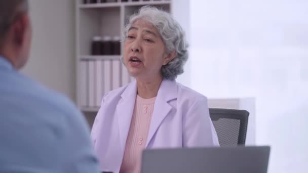 Starší asijské ženy Doktor mluvit během lékařské prohlídky na klinice konzultace s vyšším mužského pacienta v ordinaci, zdravotní péče nebo podpory v nemocnici. Vysoce kvalitní 4K záběry - Záběry, video
