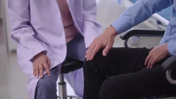 Medico anziano asiatico femminile Fisioterapista che cura l'esame pazienti anziani dolore alle ginocchia o adattamento chiropratico delle gambe in unità ortopedica in ospedale - Filmati, video
