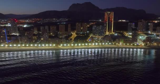 Вид с воздуха на прибрежные здания ночью в Бенидорме, Испания. Современный город у моря. - Кадры, видео