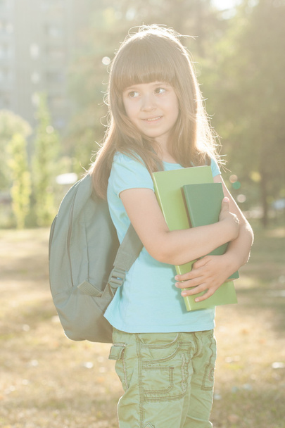 Портрет милой маленькой школьницы в парке
 - Фото, изображение