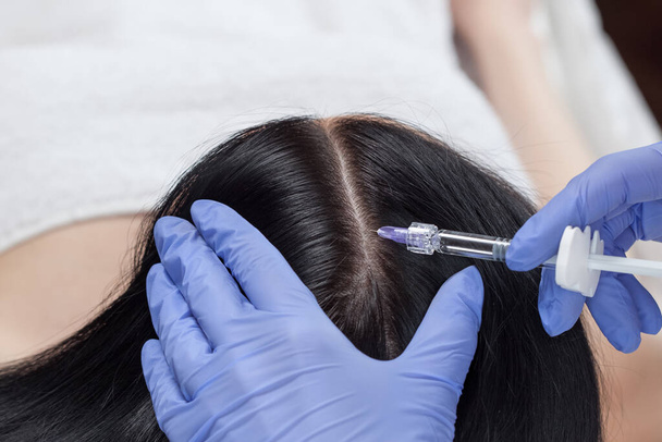 Cosmetologist faz prp terapia contra a perda de cabelo e anti-caspa de uma mulher bonita em um salão de beleza. Conceito de cosmetologia. - Foto, Imagem