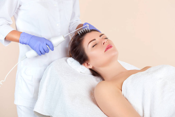 Kosmetolog sprawia, że mikroterapia przeciwko wypadaniu włosów na włosach w salonie kosmetycznym.Kosmetologia i profesjonalna pielęgnacja skóry. - Zdjęcie, obraz