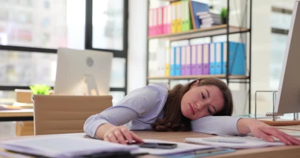 Jonge vrouw verveelt zich door uitgeput en ongemotiveerd aan de computer te werken. Apathie en luiheid op het werk - Video