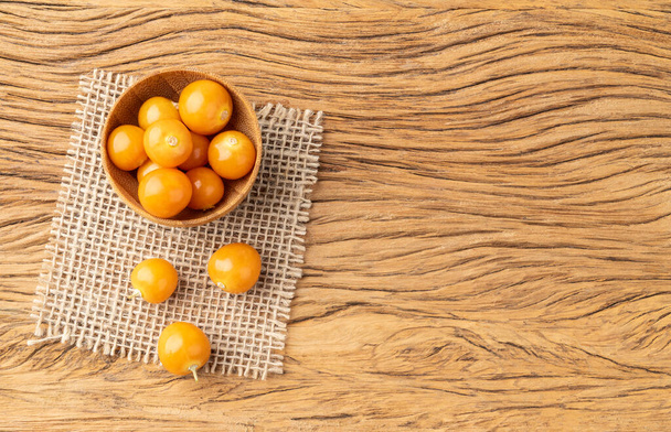 Physalis on a bowl over wooden table with copy space. - Photo, Image