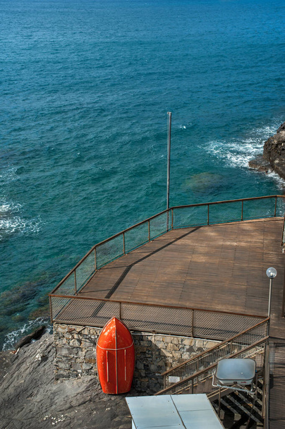 pláž terasa pro relaxaci na břehu Středozemního moře, červený záchranný člun, molo z prken - Fotografie, Obrázek