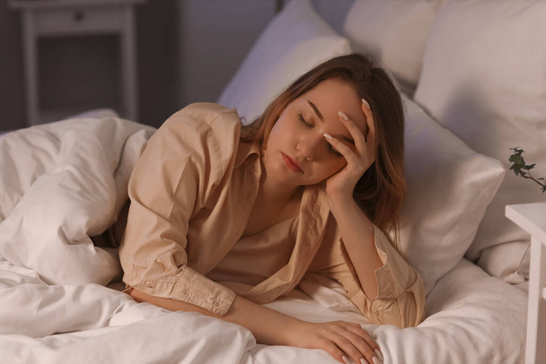 Nuori nainen makaa sängyssä yöllä - Valokuva, kuva