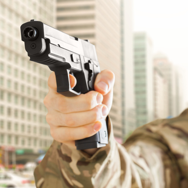 Man in city holding gun in his hand - Foto, imagen