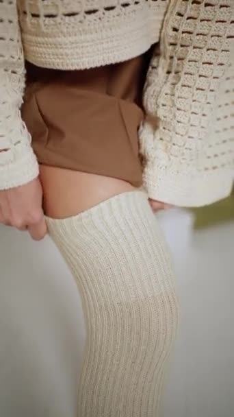 Zbliżenie kobiety zakładającej pończochy i krótką spódniczkę - Materiał filmowy, wideo