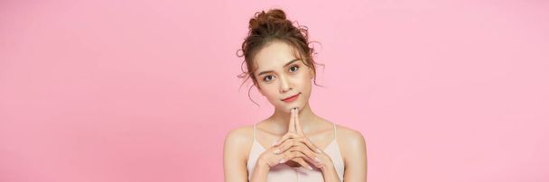 Portrait of attractive young woman over pink background - Foto, Imagen