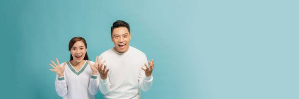 Portrait of Asian couple with surprised and excited expression isolated on turquoise banner - Photo, Image