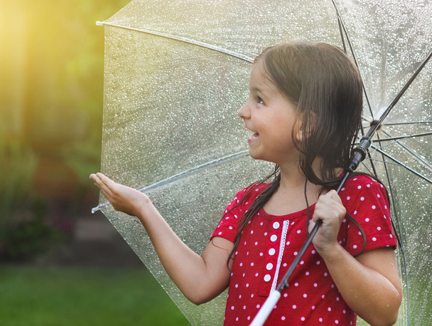 Παιδί φορώντας πουά φόρεμα κάτω από ομπρέλα στην βροχερή μέρα - Φωτογραφία, εικόνα