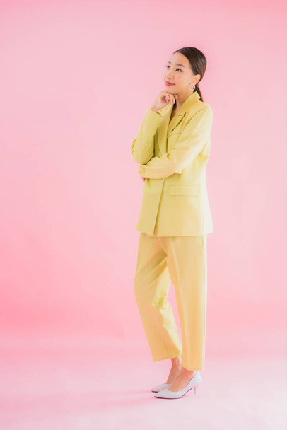 Портрет красива молода азіатська бізнес-леді посміхається в дії на фоні рожевого кольору
 - Фото, зображення