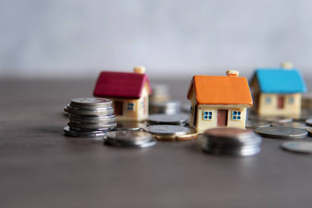 Closeup image of toy house surrounded by coins. Copy space for text. Home ownership concept. - Photo, Image