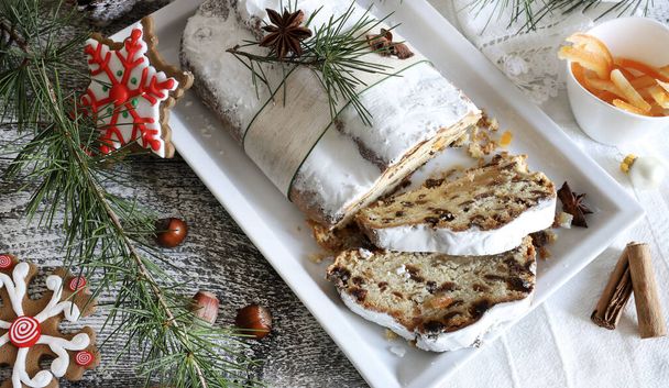 Dolce tradizionale tedesco natalizio Stollen noto anche come Christstollen tagliato a pezzi. Pasta lievitata dolce con spezie, frutta candita e frutta secca. Stagione delle vacanze.  - Foto, immagini