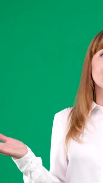On a green chromakey background, a woman solves problems, screams, swears, talks on the phone, waves her hand, office worker, white blouse, red blond hair. High quality - Filmati, video