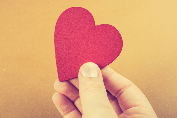 Cor vermelha coração em forma de objeto na mão em papel pontilhado - Foto, Imagem