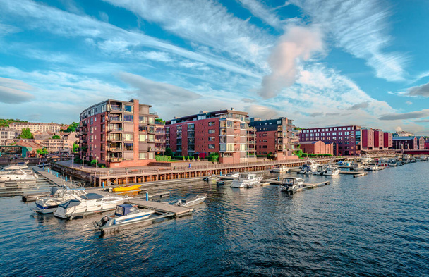 Trondheim, Νορβηγία - 19 Αυγούστου 2022: Παραθαλάσσια οικιστικά κτίρια με θέα τον ποταμό Nidelva ένα ηλιόλουστο απόγευμα. - Φωτογραφία, εικόνα