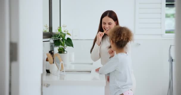 Гигиена полости рта и семья чистят зубы в ванной комнате своего дома вместе для утренней рутины. Зубная щетка, зубная паста или стоматолог с матерью и дочерью уборки в их квартире. - Кадры, видео