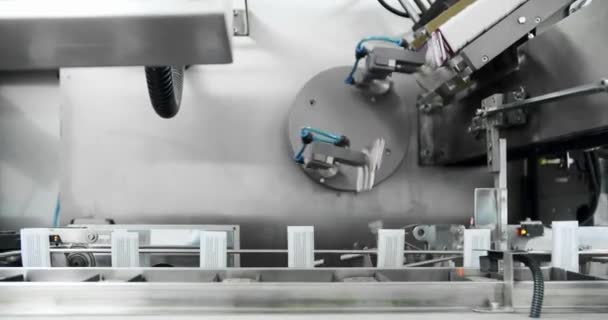 医療工場での製造ライン.ロボットアームはコンベヤベルトに医薬品パッケージを置きました.自動生産ラインでパッケージ化. ドラッグの包装。 医学の工場アセンブリ ライン パッキング医学機械 - 映像、動画