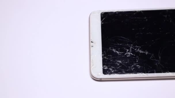 Smartphone with broken display close-up, slow motion. Damaged mobile device. Equipment insurance. Mobile device with broken touchscreen glass. Smartphone drop to the floor, screen damage - Footage, Video