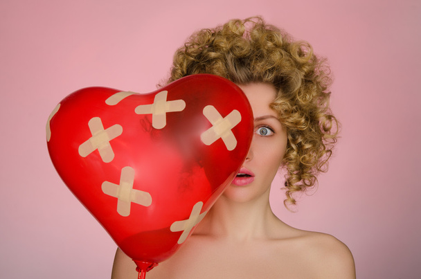 Unhappy woman with ball in shape of heart - Foto, Bild