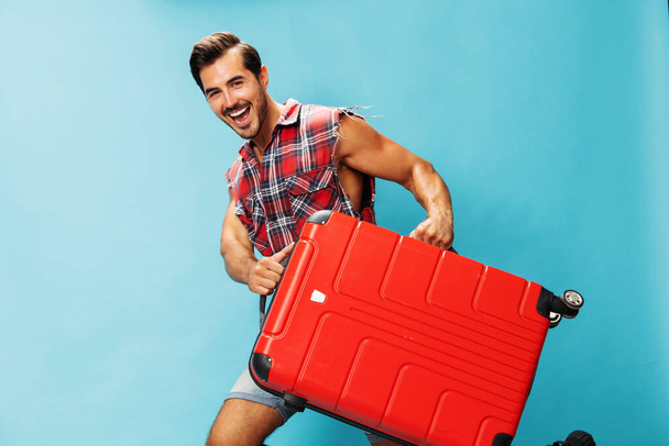 Man luggage travel blue holiday red lifestyle studio hipster happy weekend traveler tour flight holiday guy trip ticket voyage background suitcase style space journey copy baggage - Foto, Imagem