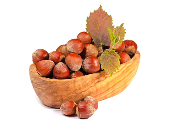 Hazelnuts in a wooden bowl against a white background - Photo, Image
