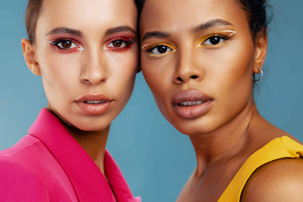 Renkli göz makyajlı kadın birlikte güzellik portresi mutlu stüdyo sarı sağlıklı ırk karışık bakım çekici Amerikan derisi iki Afrikalı kız model - Fotoğraf, Görsel