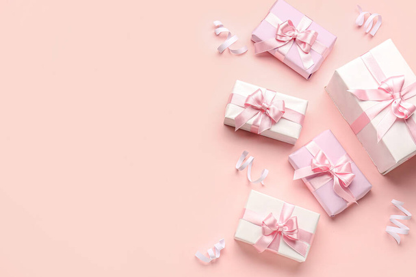Geschenkschachteln mit schönen Schleifen und Serpentinen auf rosa Hintergrund - Foto, Bild