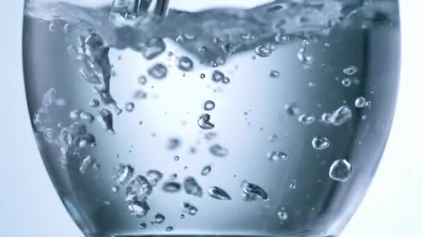 tiro de alta velocidade perto de água mineral clara derramando em vidro de bebida - Filmagem, Vídeo