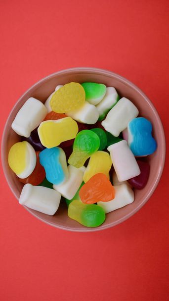 Uma tigela de doces contra um fundo colorido - Foto, Imagem