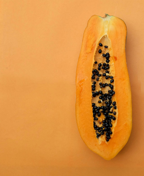 shora a plochý ležel sladký zralý papája ovoce papája s plátek izolovaný na oranžovém pozadí. zelenina a ovoce pro zdravou výživu.veganské potraviny - Fotografie, Obrázek