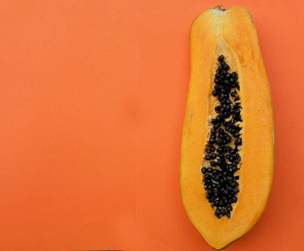 top view and flat lay a sweet ripe papaya fruit papaya with slice isolated on a orange backdrop. vegetable and fruit for healthy nutrition.vegan food - Photo, Image