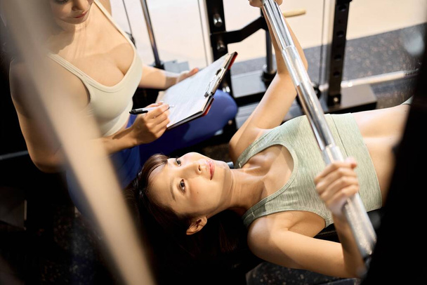 Женщина тренирует грудь с помощью пресса для штанги - Фото, изображение