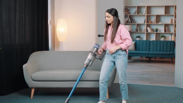vezeték nélküli porszívó és női takarítás a szőnyeg alatt otthon appartment nappali - Felvétel, videó