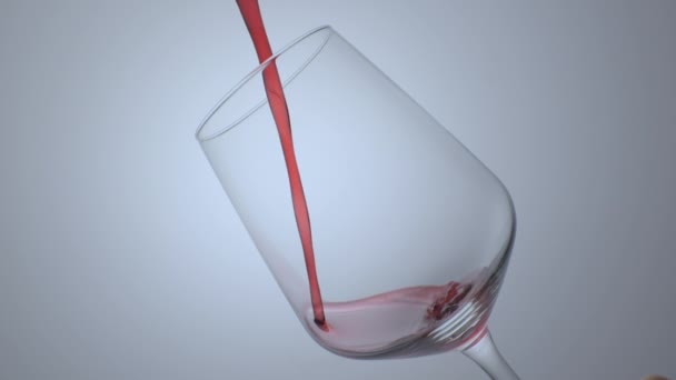El vino tinto forma una ola hermosa. Vino vierte en copa de vino sobre fondo blanco. Primer plano de tiro. Movimiento lento de verter vino tinto de la botella en la copa. - Metraje, vídeo