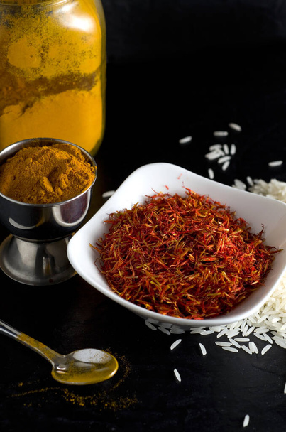 Macro Image of Fresh Saffron, Turmeric and White Rice with Dark Background Vertical - Photo, Image