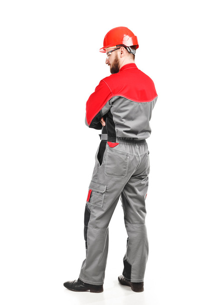 rear view of man wearing overalls with red helmet - 写真・画像