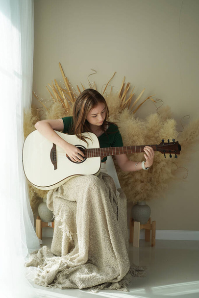 10 代の少女は、アコースティック ギターを弾く - 写真・画像