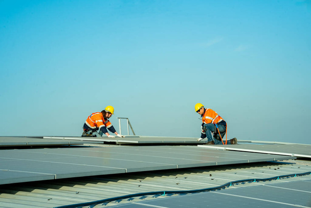 Profesyonel mühendisler güneş ışığı altında güneş çatılarını kontrol ediyorlar. Elektrik yenilenebilir eko enerji hizmeti veren mühendisler - Fotoğraf, Görsel